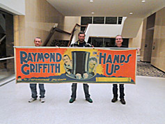 Larry, Trevor and Bruce, with Bruce Lawton's Hands Up banner