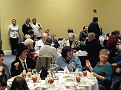 Attendees await a turn at the buffet table; wait staff stands ready to help