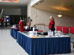 Setting up table displays in White Concert Hall lobby