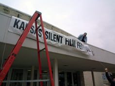 Putting up the Kansas Silent Film Festival banner outside White Concert Hall