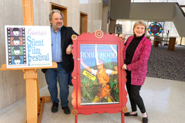 Tracey Goessel, in pink, pose with husband Robert Bader by our festival posters on Friday evening