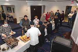 Attendees are helped by servers at the buffet tables.