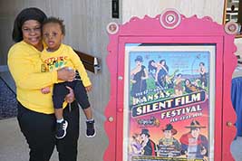 This mom and child stopped to enjoy an event poster as they took a break from watching movies.
