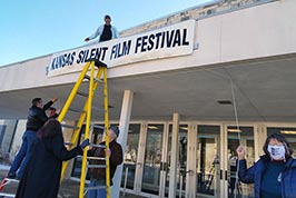 KSFF crew holds parts in place and Karl Mischler finishes securing the banner.