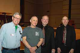 KSFF President Bill Shaffer stands near the edge of the White Concert Hall stage with staffer Larry Stendebach and musicians Jeff Rapsis and Ben Model.