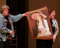 Enid assists Jane Bartholomew with a live poster auction. Poster courtesy of Nicholas Eliopoulos