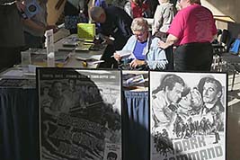 Late afternoon sun pours into the lobby as attendees take a break in the Program