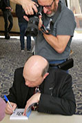 Karl Mischler photographs Ben as he signs a book