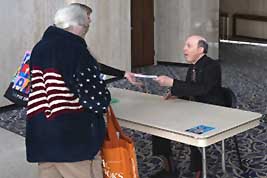 Book-buying attendees make it to the front of the line to talk with Ben Model